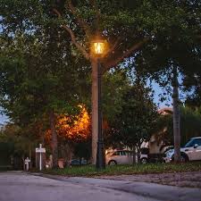 Solar pole light illuminating school campus and parking area at dusk